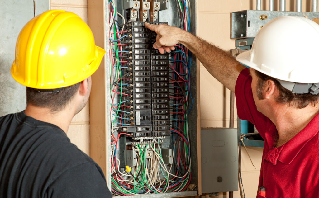 electricians inspecting breakers on a circuit panel