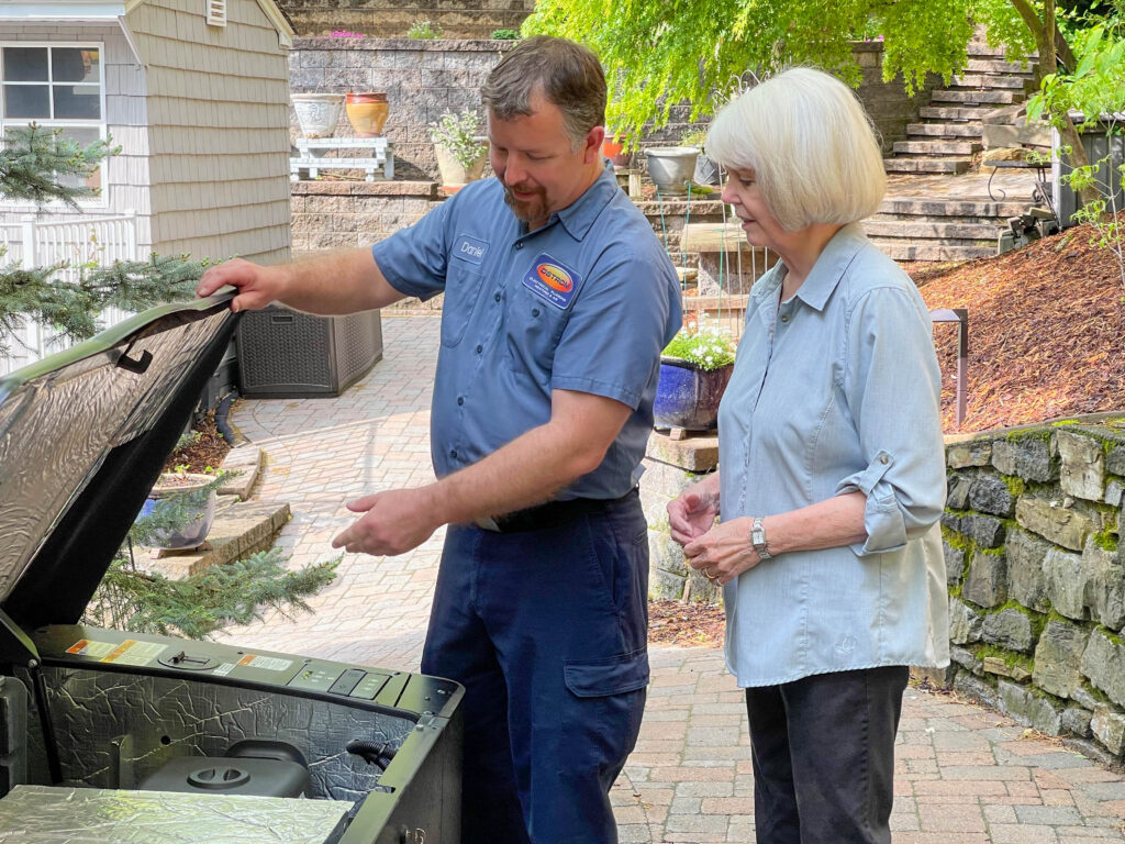 Ostrom electrician showing a customer the inside of a generator