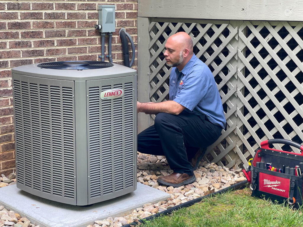 Ostrom HVAC technician servicing an air conditioner