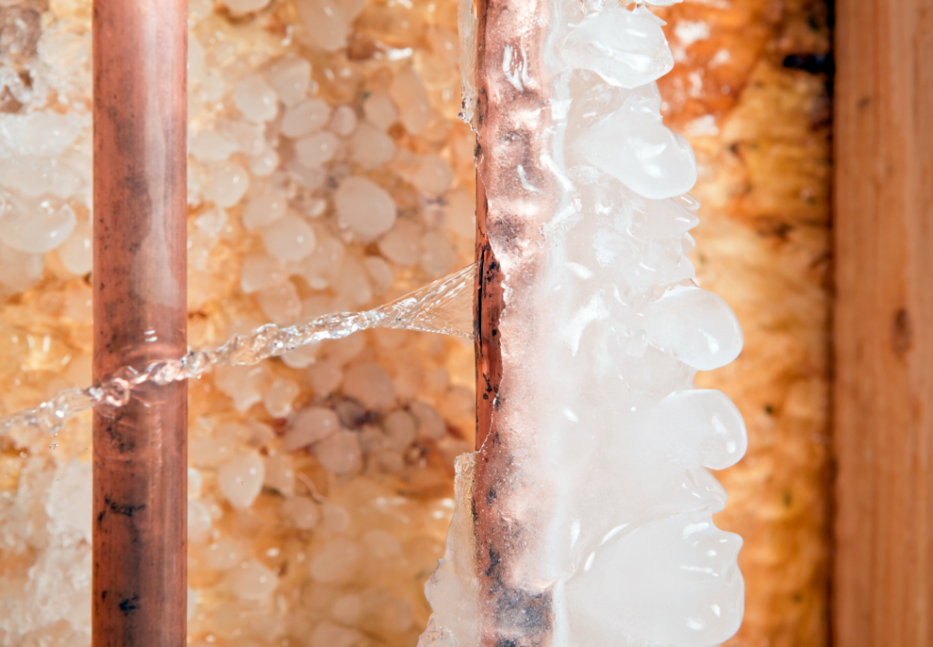 Burst frozen copper pipe covered in ice