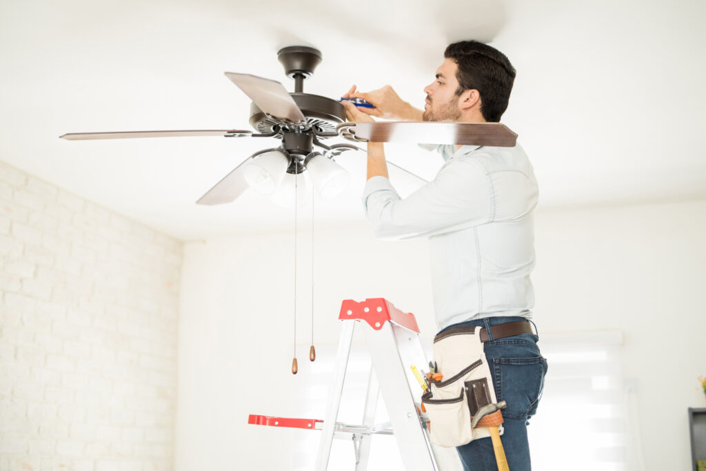 Electrician installing a ceiling fan